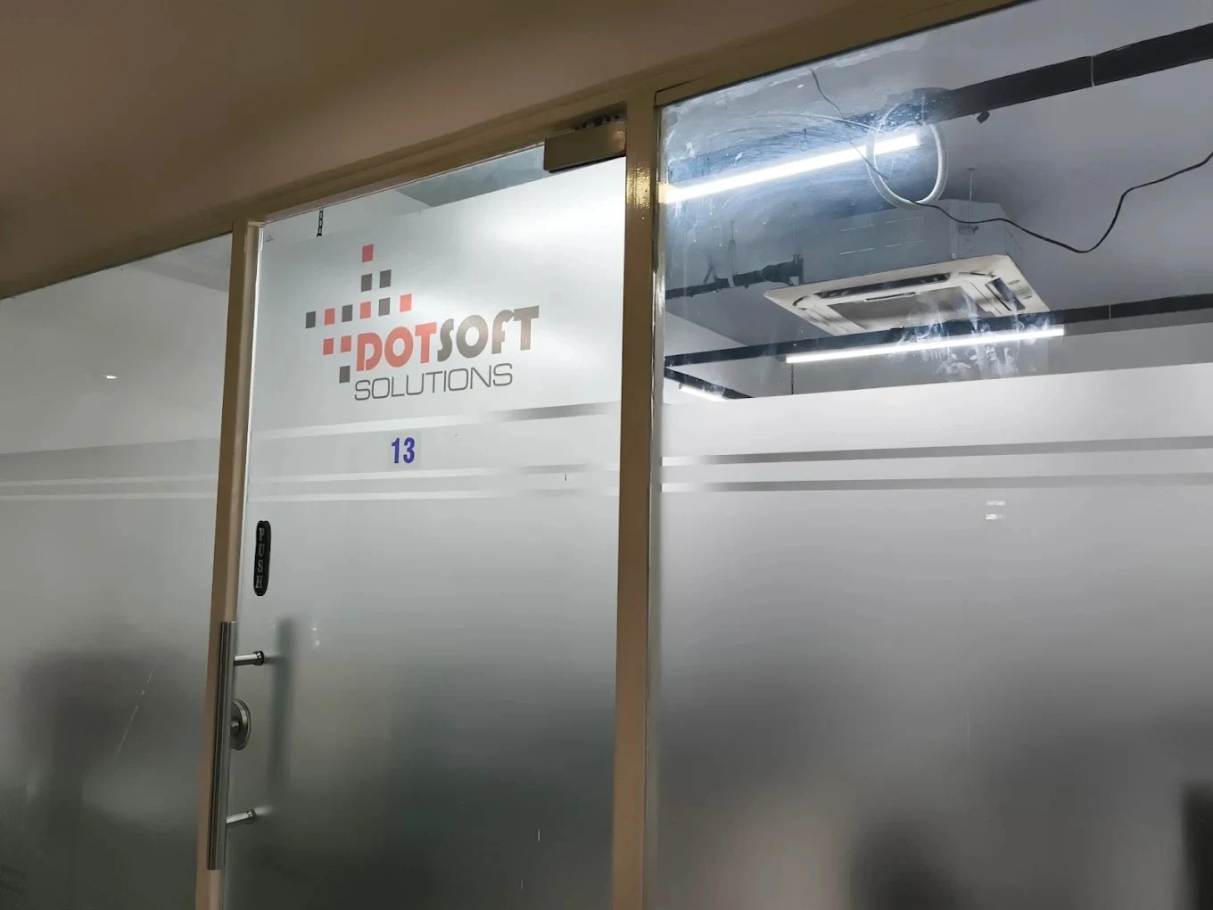 Dotsoft Solutions logo on the glass office entrance